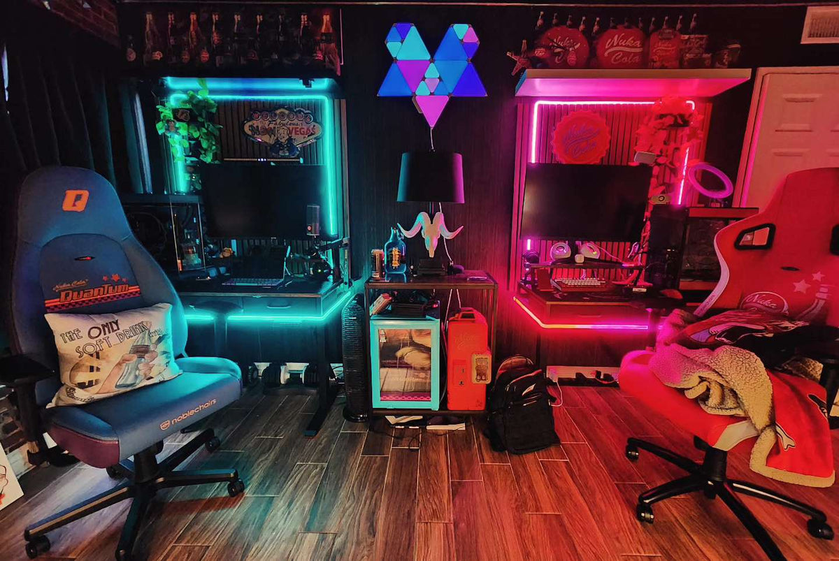 April setup contest winner room with twin gaming desks lit in teal and pink LEDs, two gaming chairs, and Fallout decor