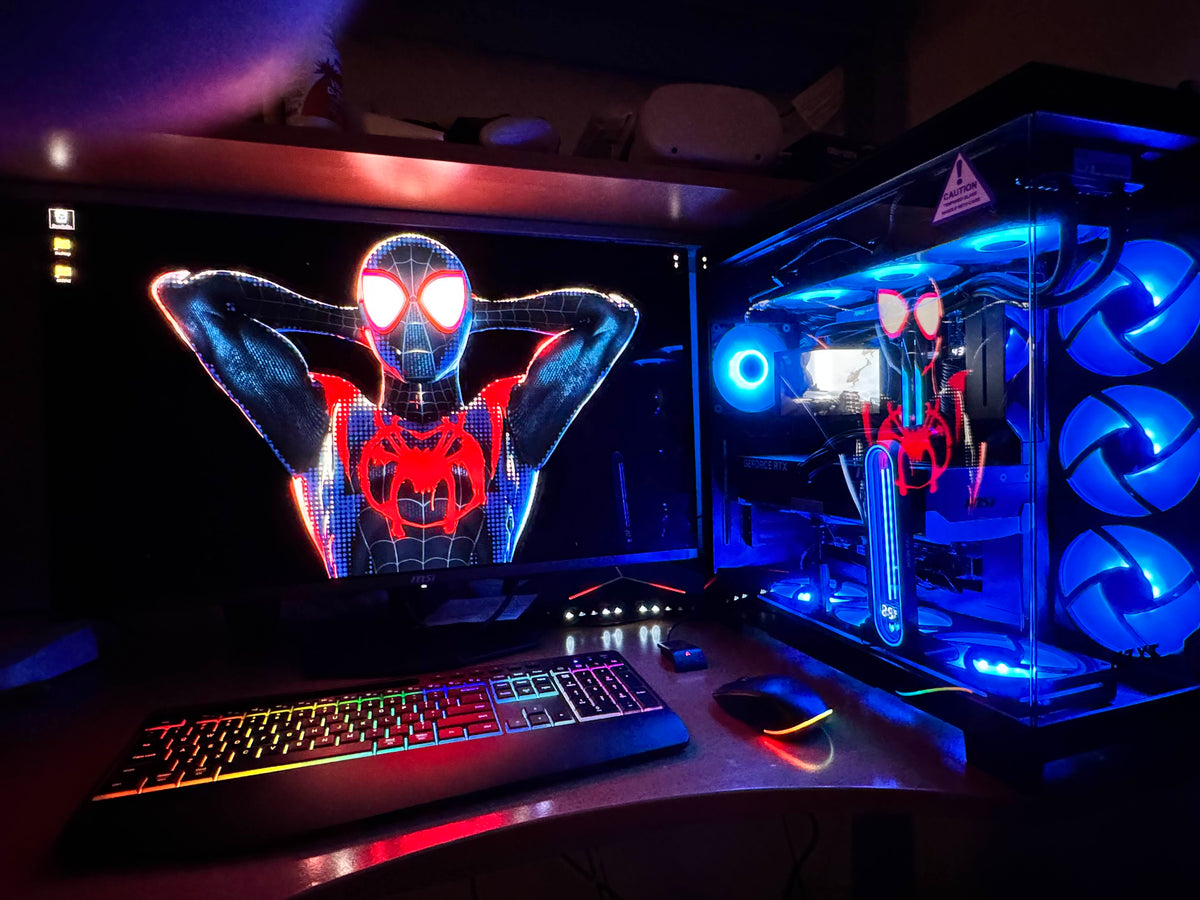 Setup contest winner desk with a Spider-Man wallpaper, RGB keyboard, and a glass PC case lit by blue fans
