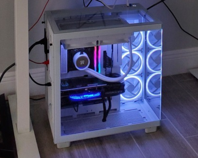 A white desktop computer with a transparent side panel shows internal components lit by blue and white LED lights, including cooling fans and a GeForce RTX graphics card, placed on a tiled floor near a desk.