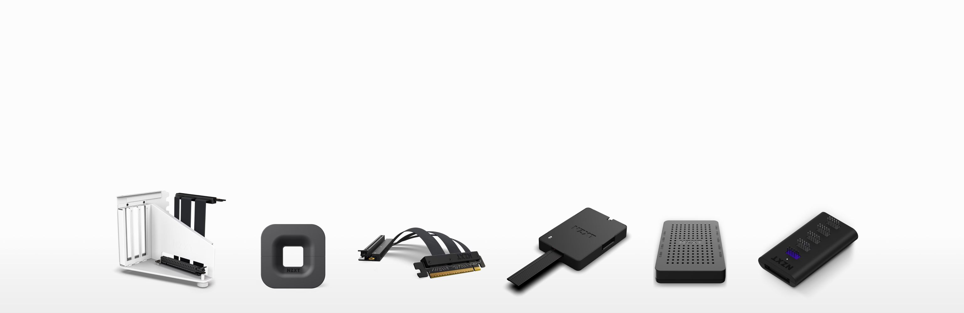 A row of various computer hardware components, including a white metal bracket, a dark square adapter, a PCIe cable, two external SSD enclosures, a perforated metal case, and a small black digital device, all on a white background.