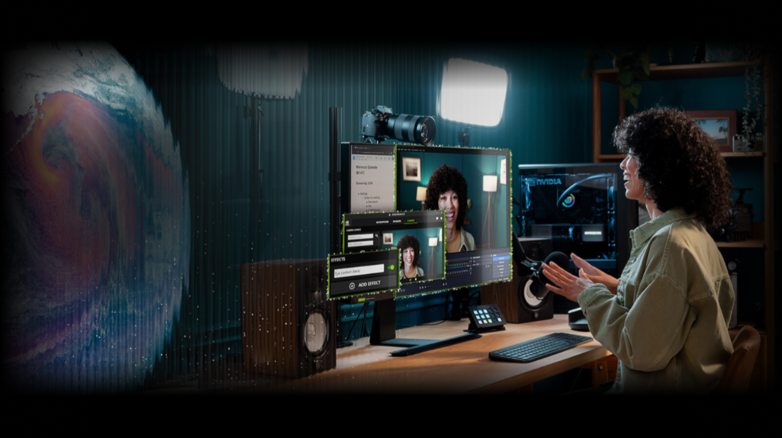 A person with curly hair sits at a desk with a computer, webcam, microphone, and studio lights, appearing to livestream or record themselves, with editing software and digital effects visible on the monitors.