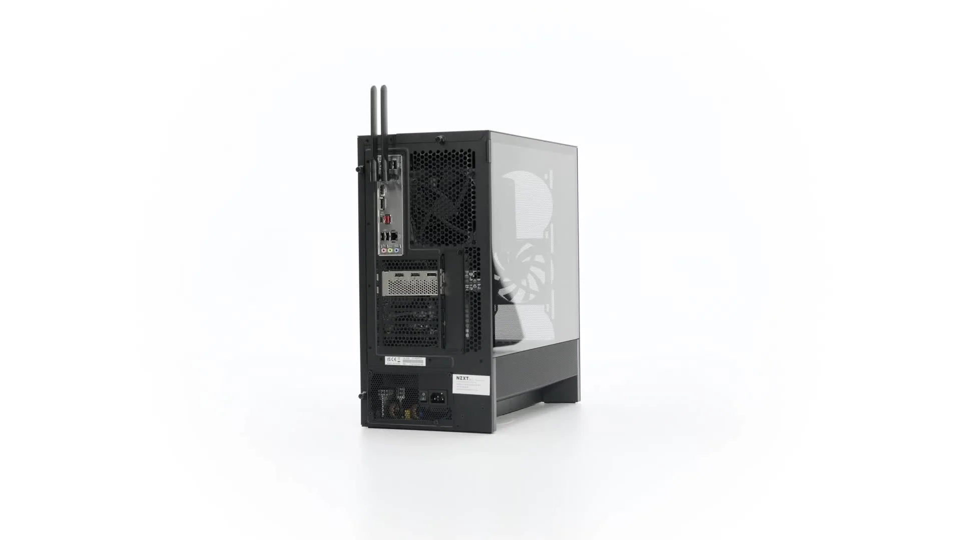 A black and silver desktop computer tower is shown from the back, displaying ports, antennas, ventilation grills, and a transparent side panel revealing internal components, against a plain white background.