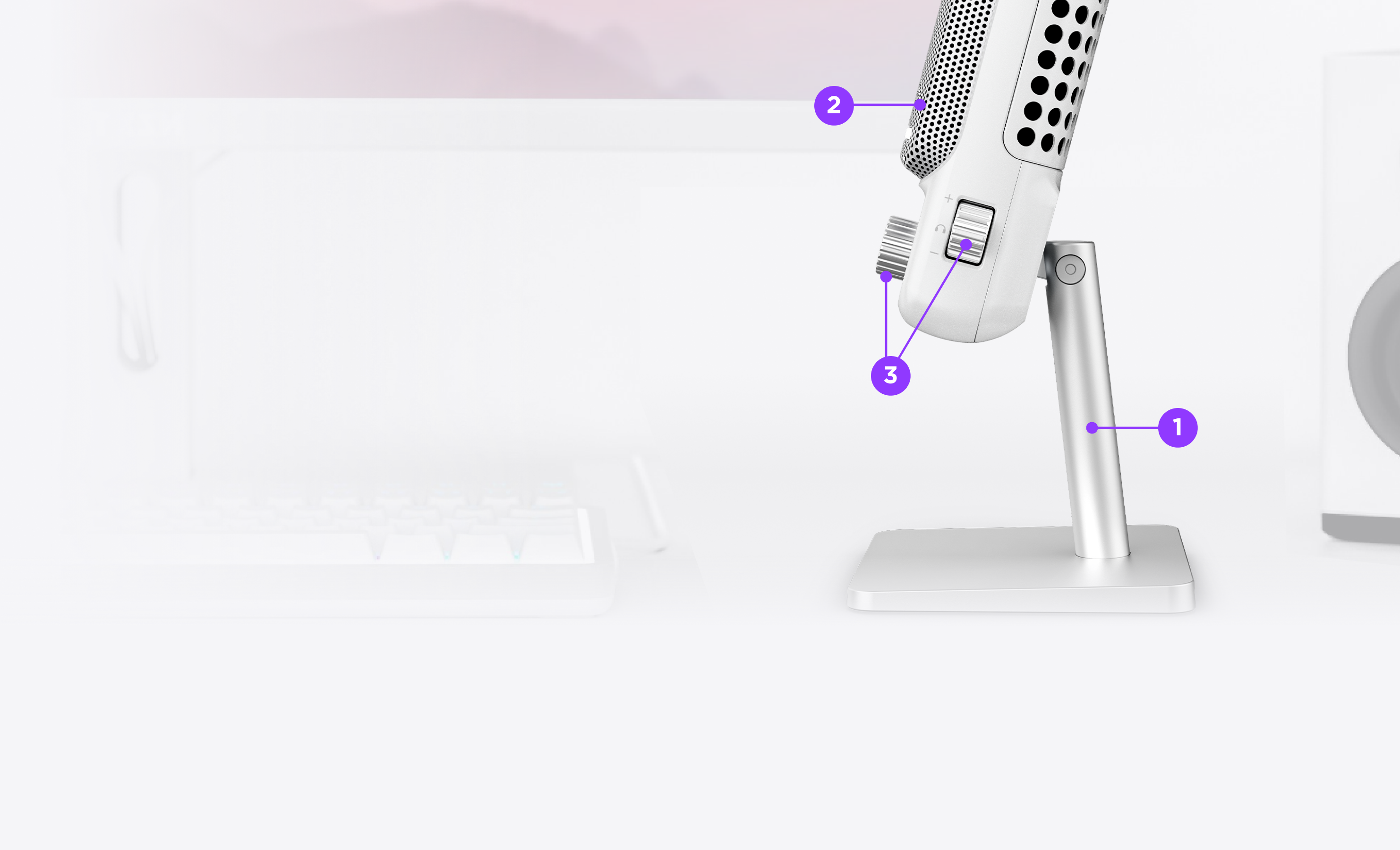 Side view of a microphone on a stand with three labeled points, in front of a blurred computer keyboard and monitor. Labels highlight the stand base, microphone body, and adjustment knob.