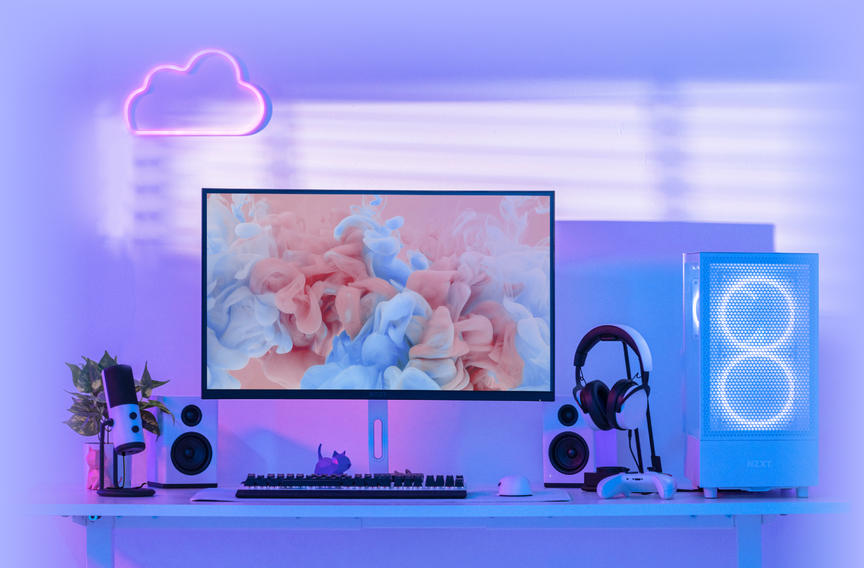 A modern gaming setup with a curved monitor displaying pastel clouds, surrounded by speakers, a microphone, headphones, mouse, and keyboard. A glowing PC and pink neon cloud light decorate the minimalist desk.